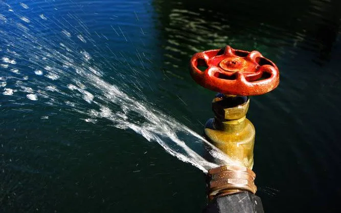 Eine Wasserleitung mit Wasser, das aus ihr herausfliesst.